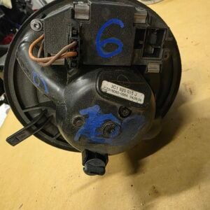 Close-up of a circular black automotive blower motor housing with exposed wires and a blue number 6 marked on it.