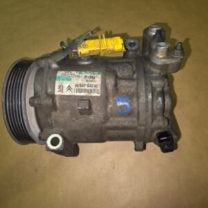 Automotive air conditioning compressor with a large drive pulley on the left and a yellow electrical connector on top.